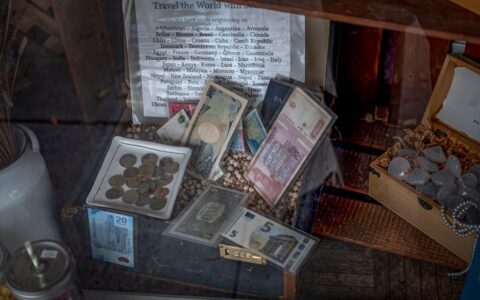 A diverse collection of global coins and banknotes displayed in a vintage setting.